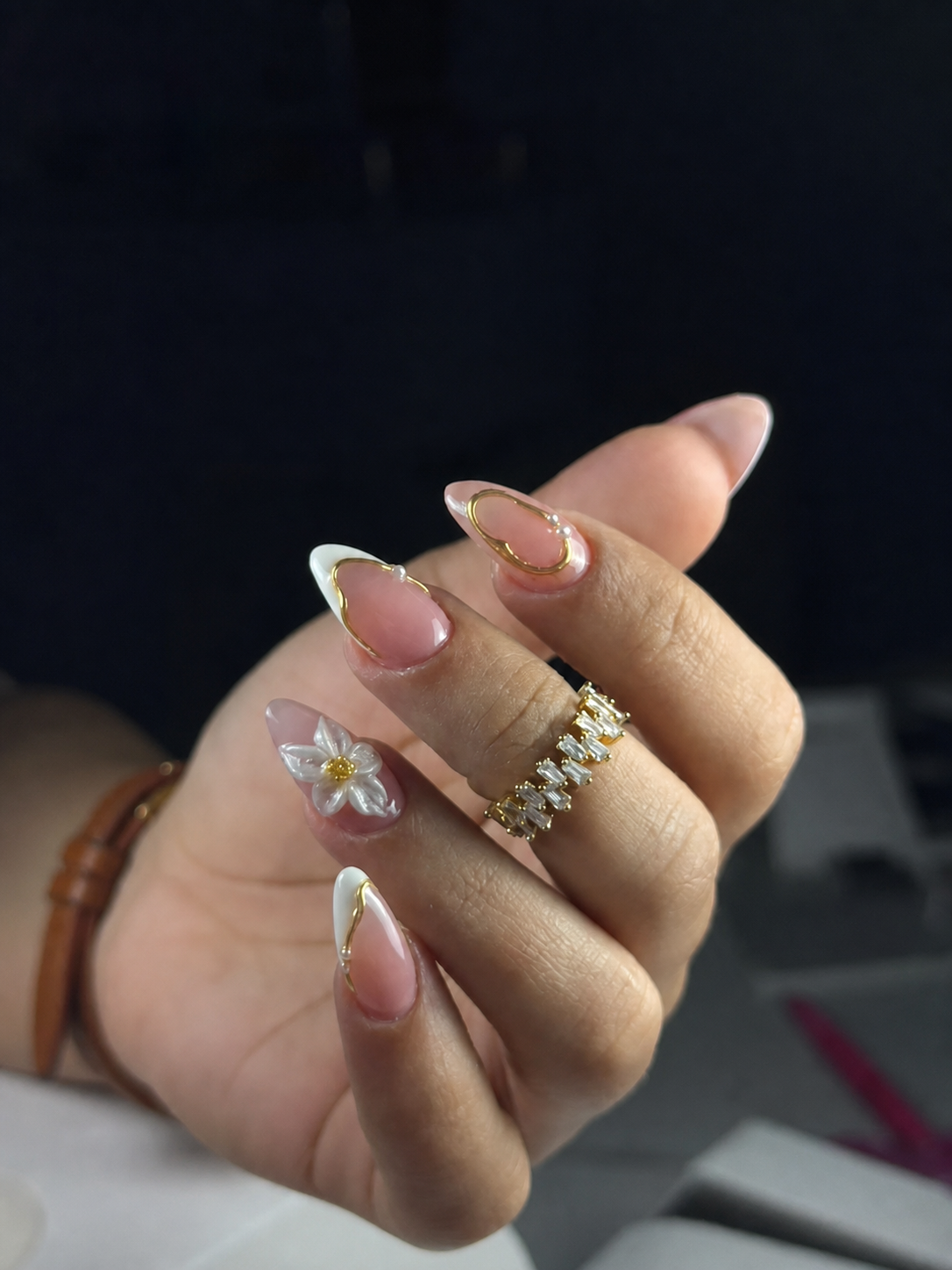 Nude almond manicure with gold lines and white flower